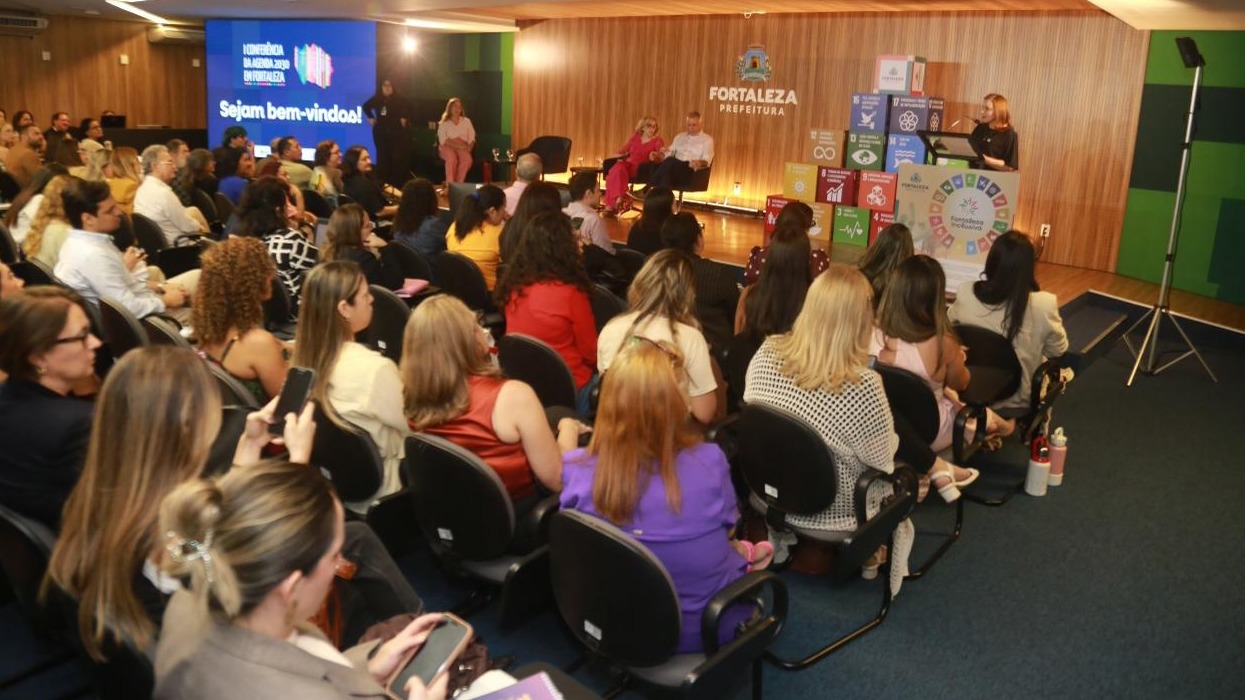 A foto mostra o auditório do Paço Municipal durante a mesa de abertura da conferência, com os participantes ocupando as cadeiras.